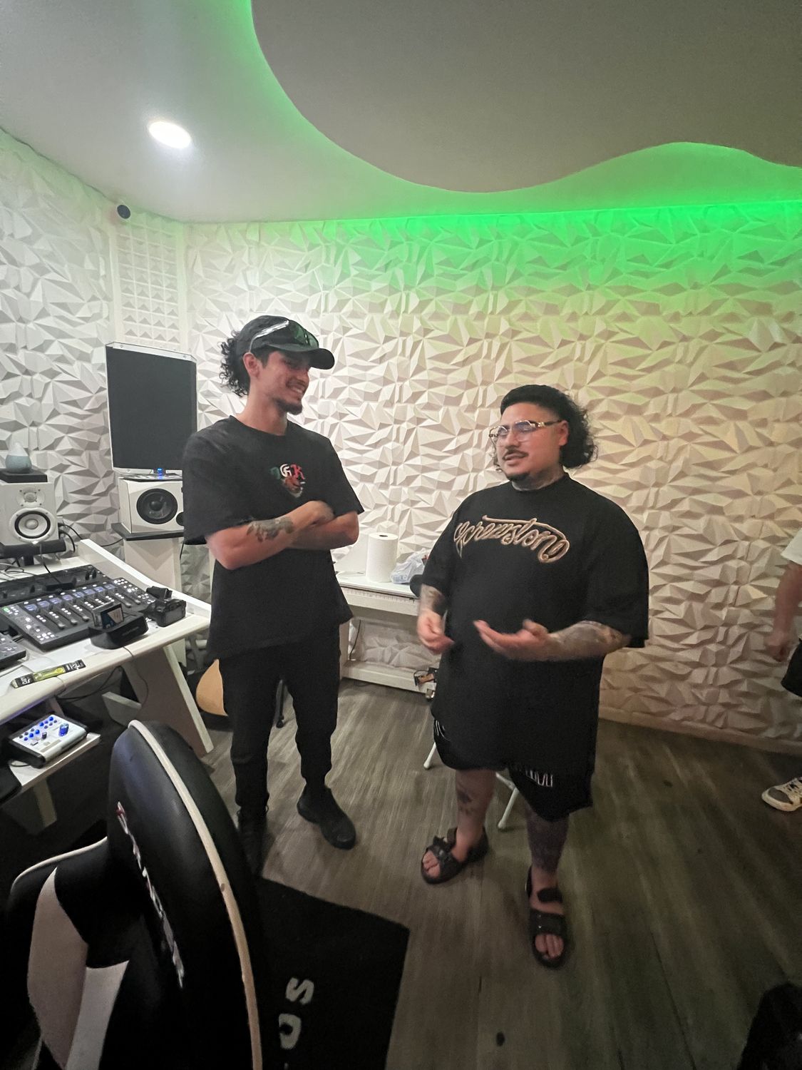 Two artists talking in the Des Del Barrio studio under green light